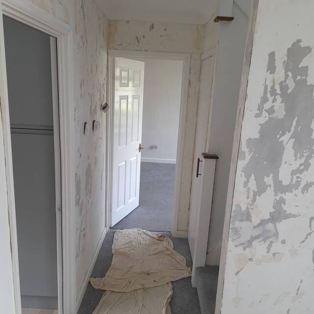 Before: hallway with old wallpaper stripped