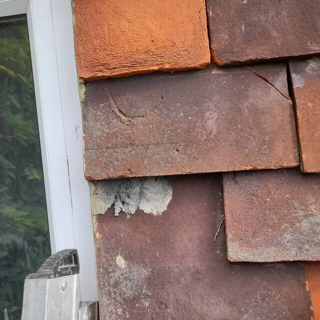 Before: clay roof tiles beside a window